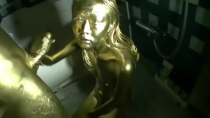 Erotic Japanese woman with gold body paint engages in sensual activity